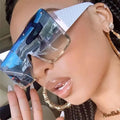 Close-up of a person wearing clear sunglasses with blue lenses and gold accents.