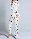 white women’s button down pajama set with black stars and moon print on a light background, soft long sleeve sleepwear suit, cozy celestial nightwear loungewear for women