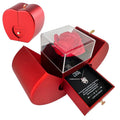 Red heart-shaped box with a rose and necklace inside on a white background