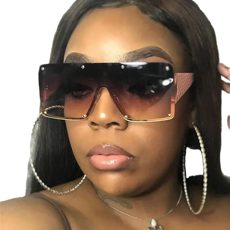Close-up of a person wearing clear sunglasses with blue lenses and gold accents.