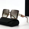 Sunglasses with gold accents on a black case against a white background