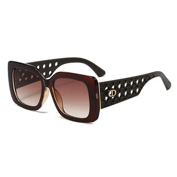 Sunglasses with decorative black frame and brown gradient lenses on a white background