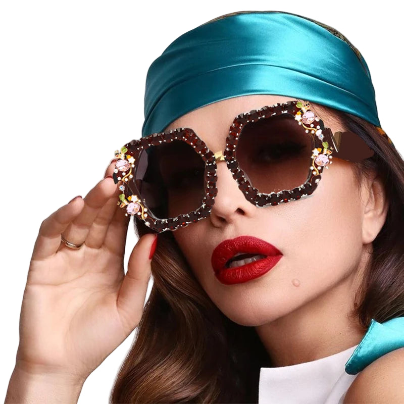 Woman wearing a turquoise headband and ornate sunglasses with red lipstick.
