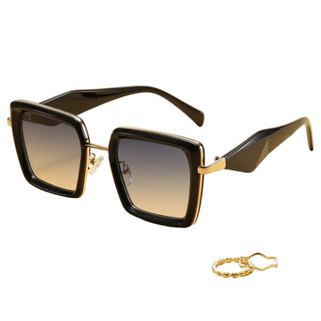 Black sunglasses with gold accents on a beige background