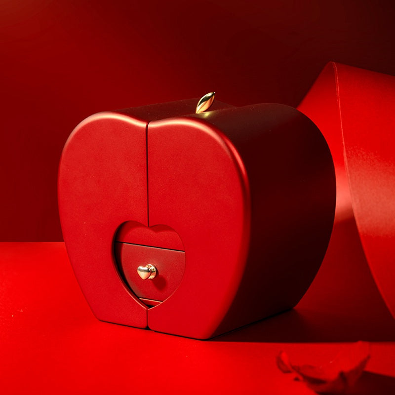 Red heart-shaped box with gold accents on a red background