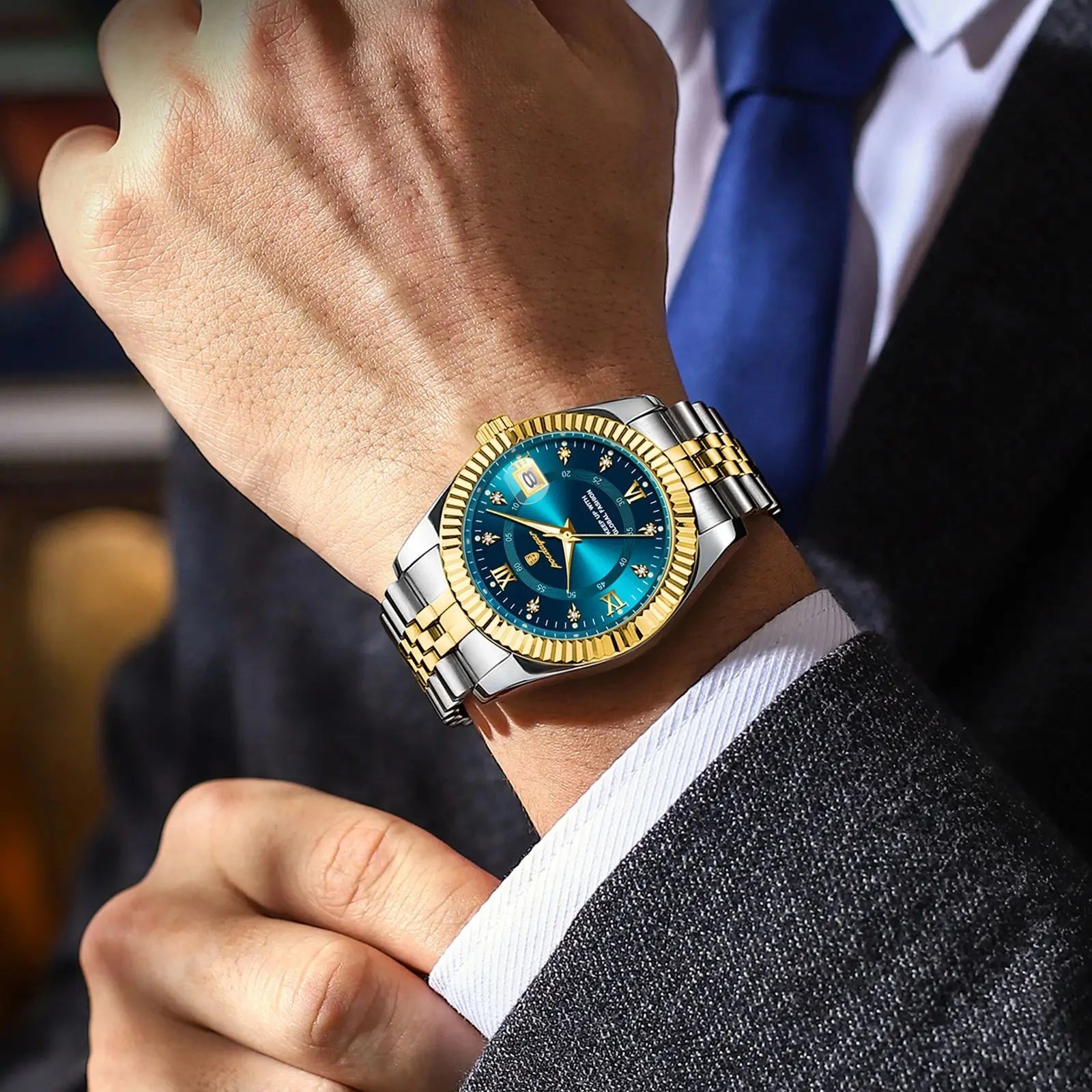 Refined men’s quartz waterproof watch with blue dial, luminous hands, date display, gold and silver stainless steel strap, worn with formal suit style