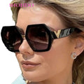 Woman wearing black sunglasses with a blurred outdoor background
