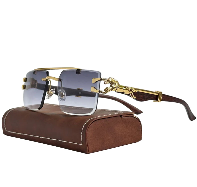 Gold-framed sunglasses with clear lenses on a brown leather case against a white background