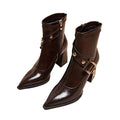 Pair of brown leather boots with gold buckles on a white background