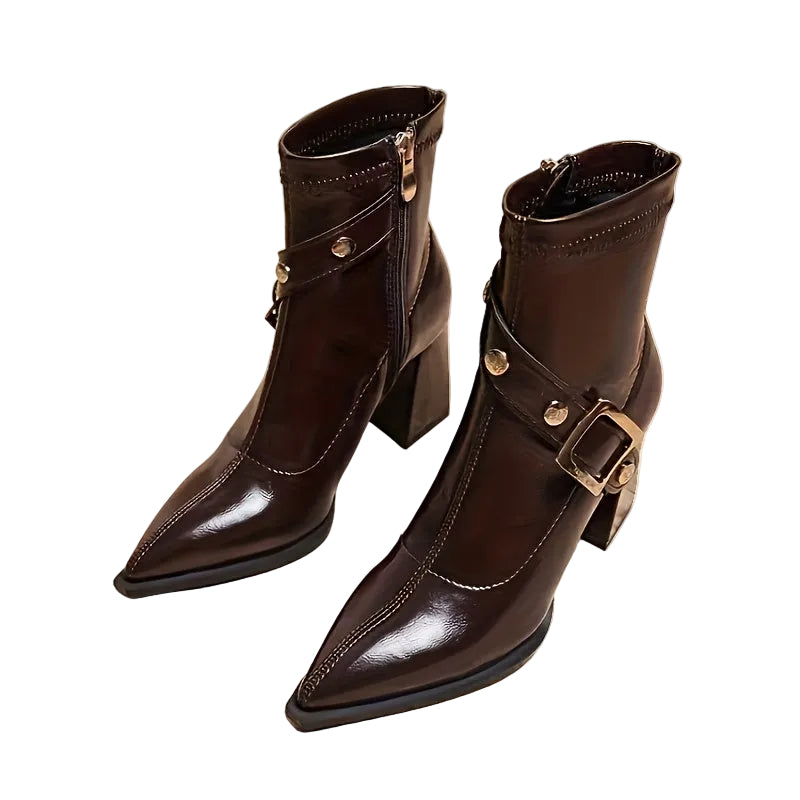 Pair of brown leather boots with gold buckles on a white background