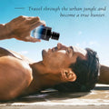 Man lying on a beach with a bottle of Shalimar perfume, text overlay 'Travel through the urban jungle and become a true hunter'.