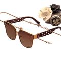 Luxury sunglasses with decorative chain and floral accessory on a white background