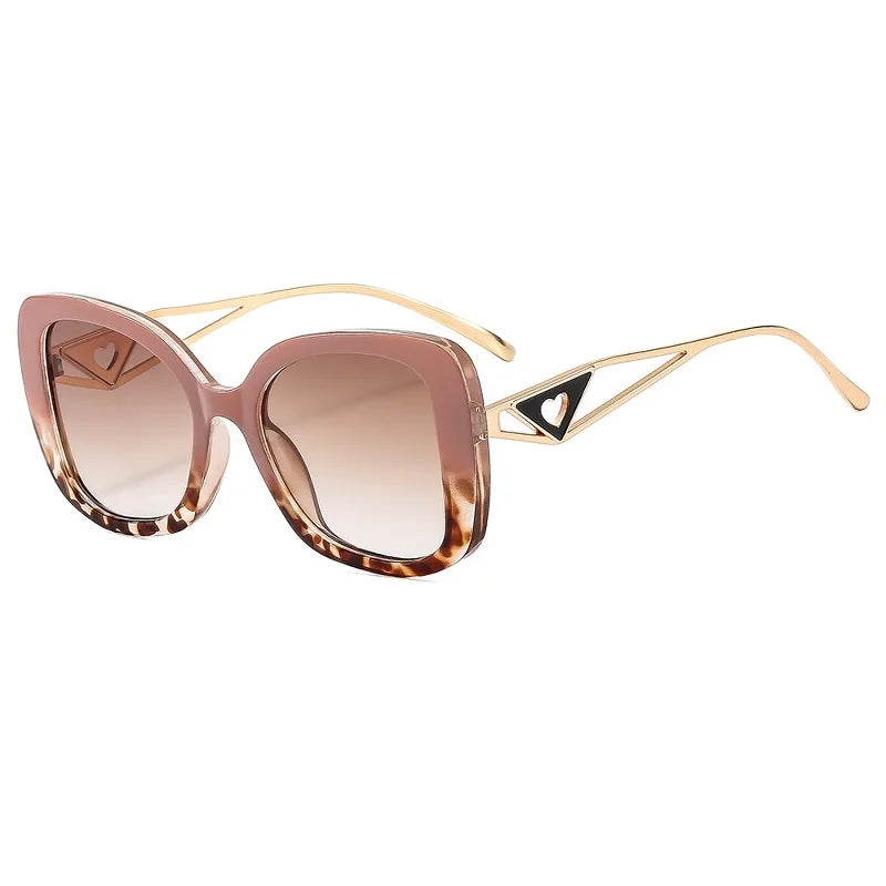 Sunglasses with pink and gold frame and green lenses on a white background