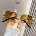 Gold sunglasses held by a hand with a neutral background