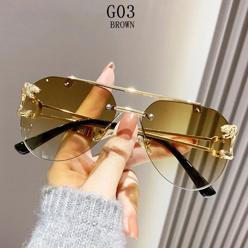Gold sunglasses held by a hand with a neutral background
