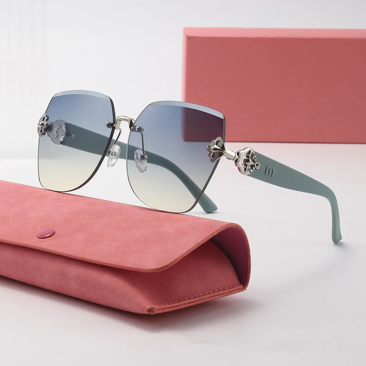 Sunglasses with decorative elements on a pink case against a light background