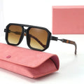 Sunglasses with brown gradient lenses on a pink case against a white background