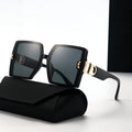 Black sunglasses with gold accents on a white background