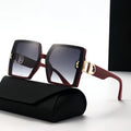 Sunglasses with gold accents on a black case against a white background