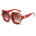 Red sunglasses with gemstone embellishments on a white background