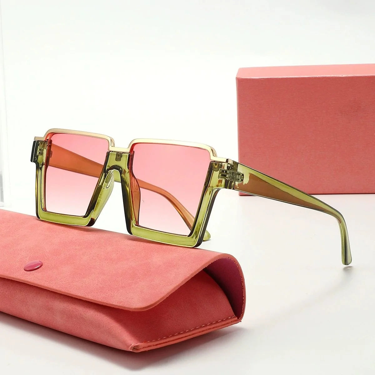 Sunglasses with pink and green gradient lenses on a pink case with a matching box.
