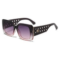 Sunglasses with black perforated frame and purple gradient lenses on a white background