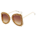 Gold-framed sunglasses with brown gradient lenses on a white background