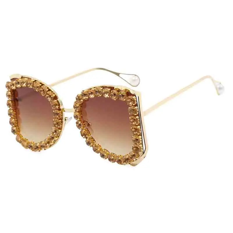 Gold-framed sunglasses with brown gradient lenses on a white background