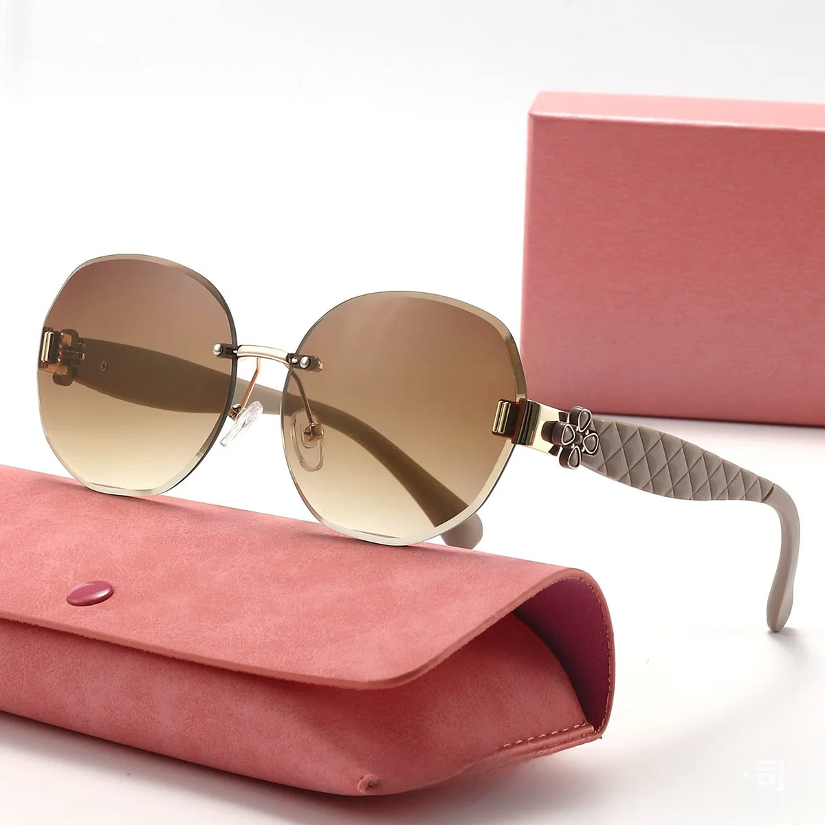 Sunglasses with quilted arm on a pink case against a white background