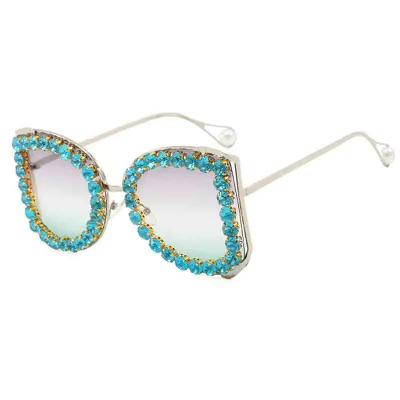 Sunglasses with turquoise and gold embellishments on a white background