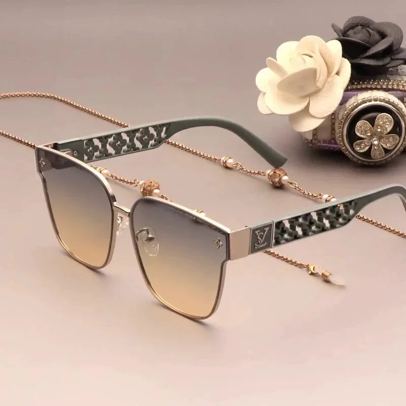 Sunglasses with decorative chain, rose gold frame, and gradient lenses on a white background.