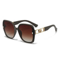 Sunglasses with a gold frame and brown gradient lenses on a white background