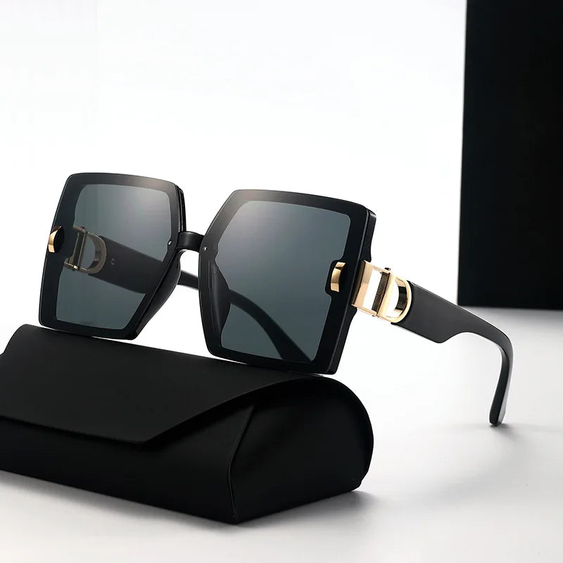 Black sunglasses with gold accents on a white background