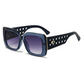 Sunglasses with black perforated frame and gradient purple lenses on a white background