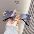 Sunglasses with gold frames and blue lenses held by a hand against a neutral background