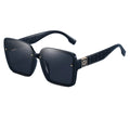 Black sunglasses with gold accents on a reflective surface