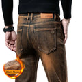 Brown jeans with a 'Warm Fleece' feature indicated by flames and text, on a dark background.