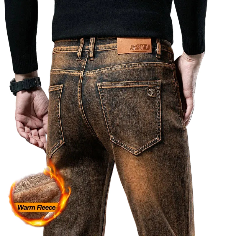 Brown jeans with a 'Warm Fleece' feature indicated by flames and text, on a dark background.