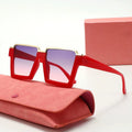 Red sunglasses with gold accents on a pink case against a white background