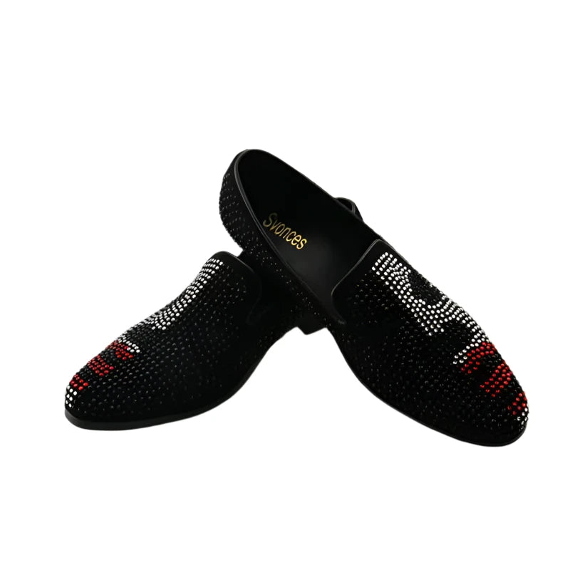 A pair of men's luxury crystal studded slip-on loafers in black with red and white accents.