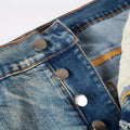 Close-up of a blue denim jacket with metal buttons on a light gray background