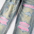 Distressed denim jacket with pink and white paint splashes on a light background