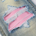 Pink and blue distressed patch on denim fabric
