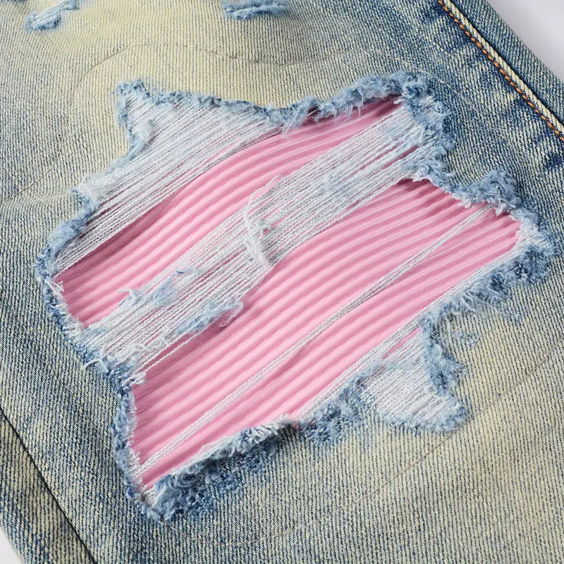 Pink and blue distressed patch on denim fabric