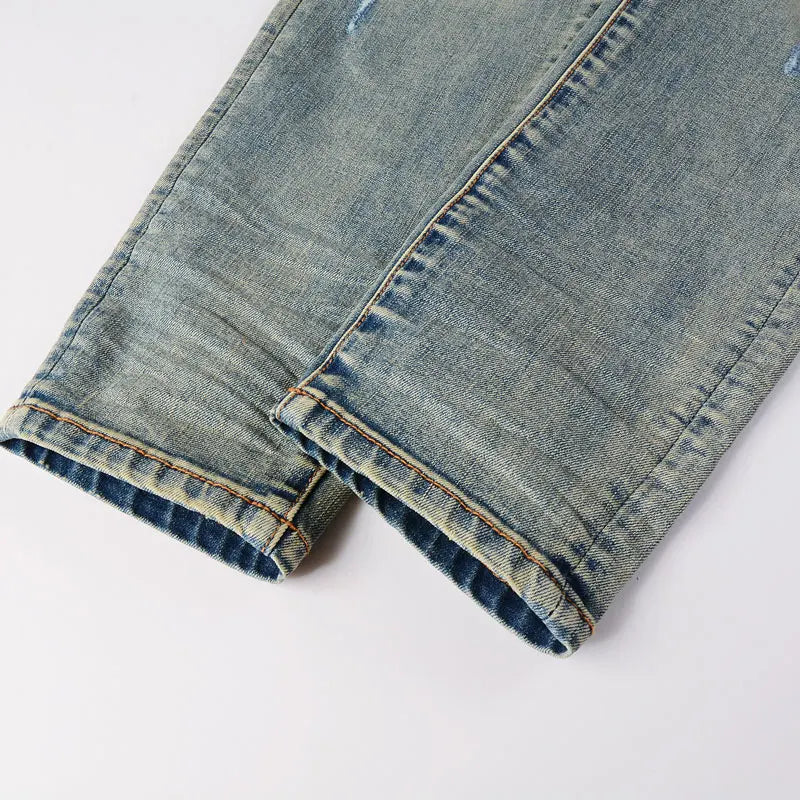 Close-up of rolled-up blue denim jeans on a white background