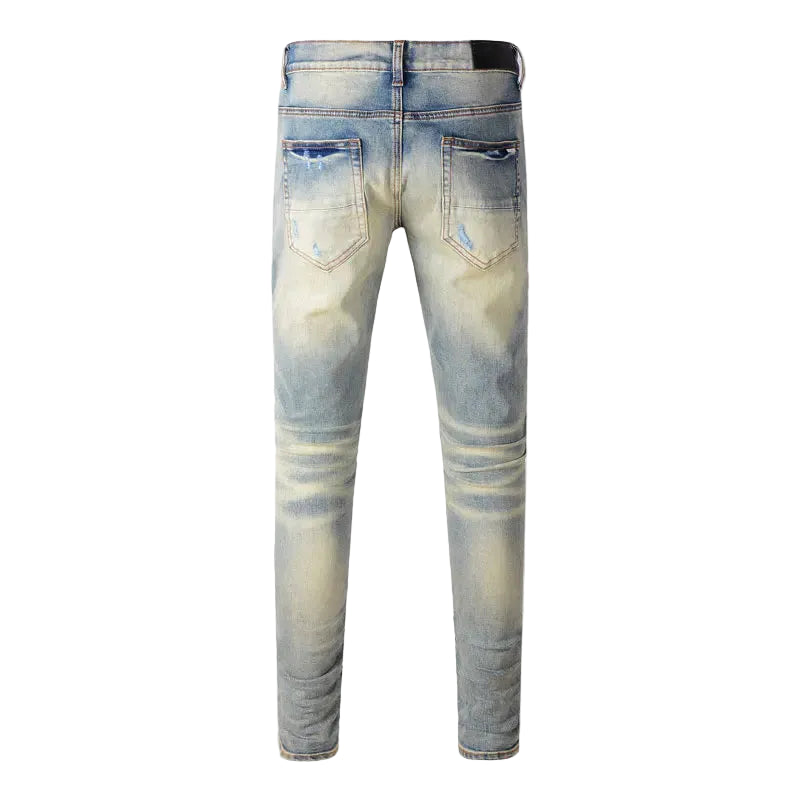 Distressed jeans with pink patches on a white background