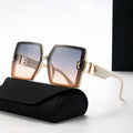 Sunglasses with gold accents on a black case against a white background