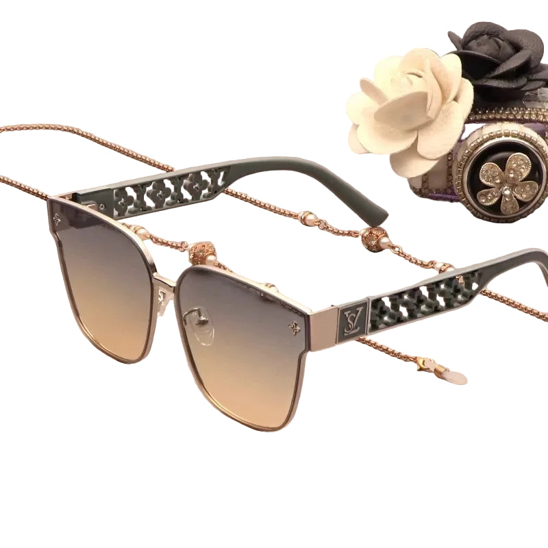 Luxury sunglasses with decorative chain, rose gold frame, and gradient lenses on a white background.