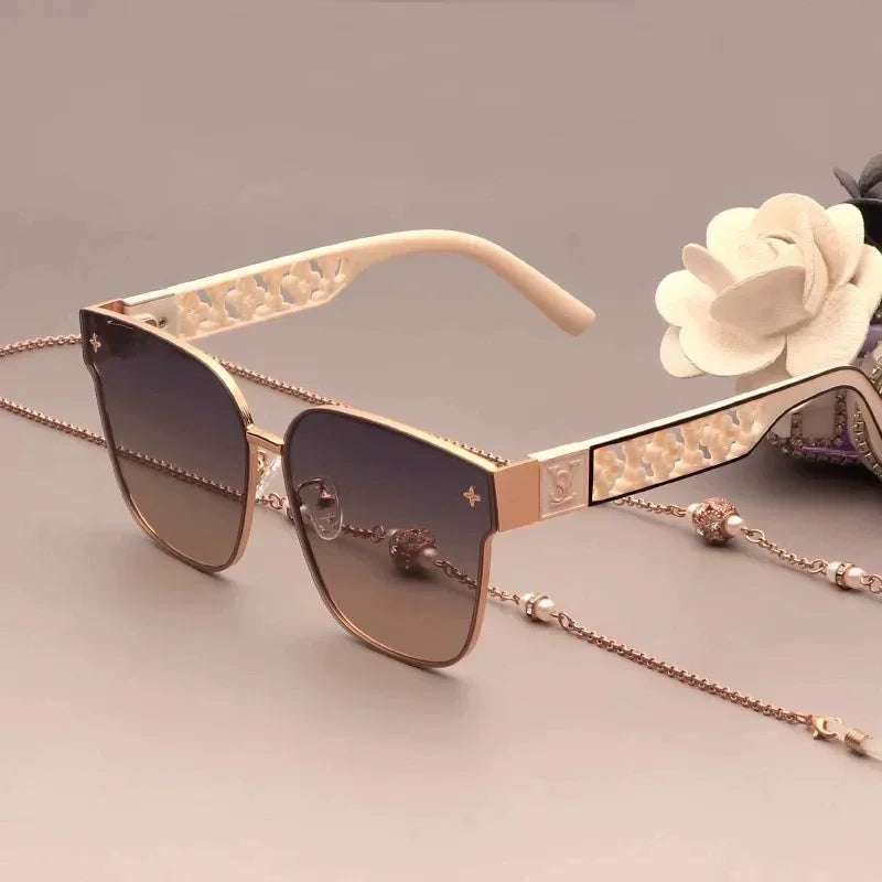 Sunglasses with decorative chain and floral accessory on a white background