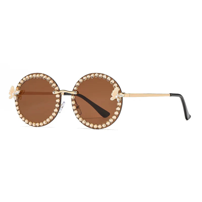 Round sunglasses with brown lenses and gold frame on a white background